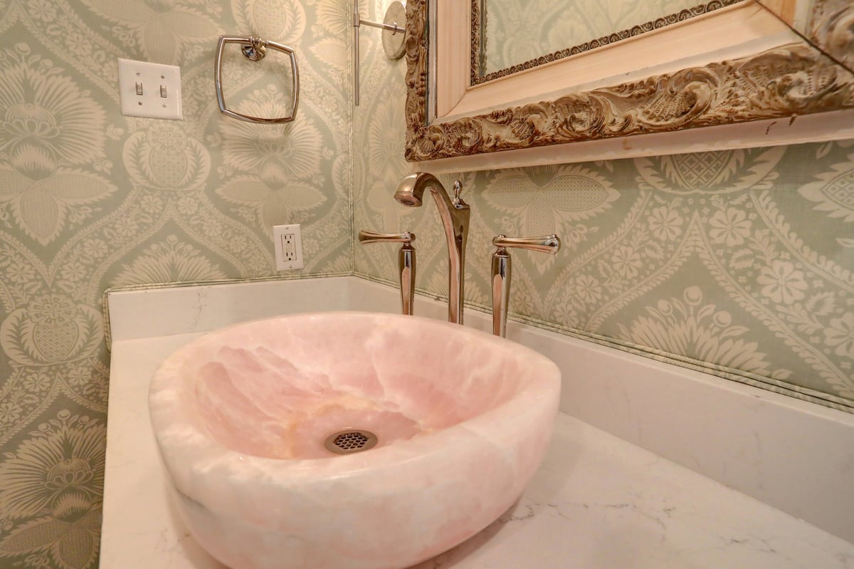 Pink Marble sink atop simple white counter