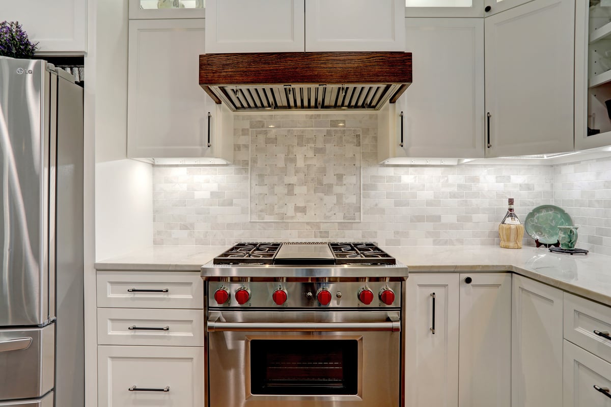 Modern stove top harmoniously blends with pristine white countertops, exuding sleek sophistication and minimalist elegance in the kitchen.