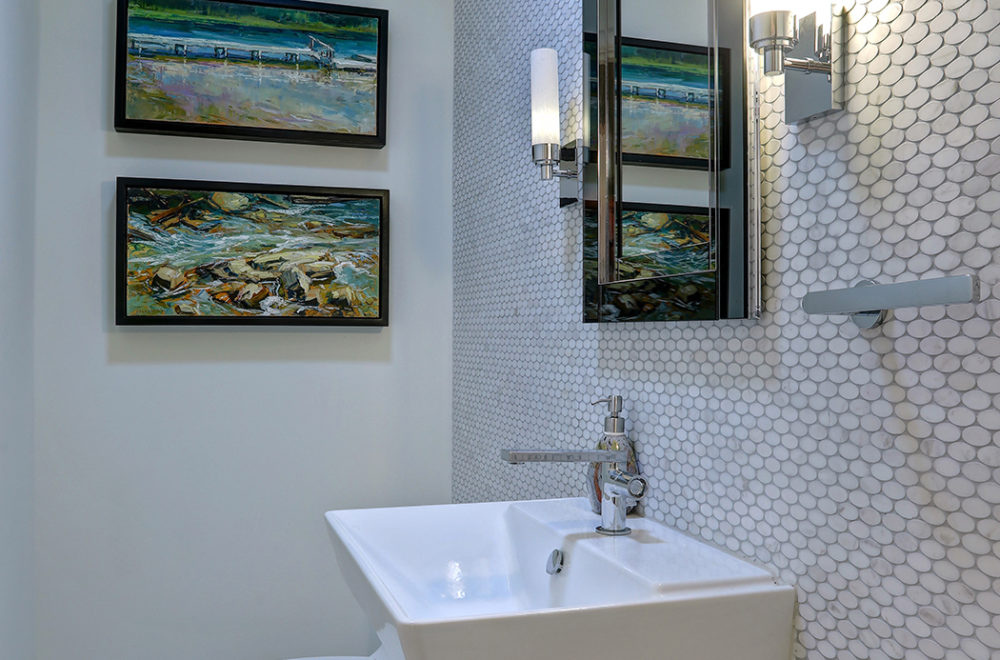 White Sink in Bathroom with Hexagon Backsplash and Art on Walls
